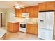 Well-lit kitchen featuring tile flooring, wooden cabinetry, and modern white appliances at 122 E Orange St, Hillsborough, NC 27278