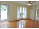 Inviting living room featuring hardwood floors, neutral walls, ceiling fan, and bright natural light at 122 E Orange St, Hillsborough, NC 27278