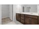 Bathroom featuring a double vanity with dark wood cabinets, tile floors, and ample lighting at 140 Azure Mist Dr, Raleigh, NC 27610