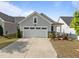 Charming single-story home features a two-car garage, manicured landscaping, and concrete driveway at 140 Azure Mist Dr, Raleigh, NC 27610
