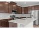 Modern kitchen featuring dark wood cabinets, a quartz island, and stainless steel appliances at 140 Azure Mist Dr, Raleigh, NC 27610