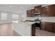 Modern kitchen features a large island, stainless steel appliances, and dark wood cabinets at 140 Azure Mist Dr, Raleigh, NC 27610