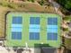 Aerial view of community tennis courts with blue and green surface at 140 Azure Mist Dr, Raleigh, NC 27610