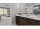 Bathroom vanity with marble countertops, dark wood cabinets, and a decorative mirror at 1416 Bailey Hill Dr, Raleigh, NC 27614