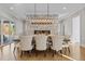 Elegant dining room featuring a stone fireplace, hardwood floors and modern chandelier at 1416 Bailey Hill Dr, Raleigh, NC 27614