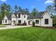 Striking white home featuring manicured landscaping, black framed windows, and a horseshoe driveway at 1416 Bailey Hill Dr, Raleigh, NC 27614