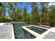 Infinity pool with spa, surrounded by lush greenery and lounge chairs at 1416 Bailey Hill Dr, Raleigh, NC 27614