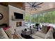 Cozy outdoor living area with a fireplace, television, and views of the pool and backyard at 1416 Bailey Hill Dr, Raleigh, NC 27614