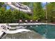 Modern pool featuring an umbrella-covered lounge area and stylish in-pool chaise lounges at 1416 Bailey Hill Dr, Raleigh, NC 27614