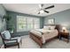 Comfortable bedroom with a wood-framed bed, ceiling fan, and natural light streaming through the window at 1416 Heritage Links Dr, Wake Forest, NC 27587