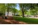 Beautifully landscaped front yard with mature trees, a well-maintained lawn, and charming outdoor seating at 1416 Heritage Links Dr, Wake Forest, NC 27587