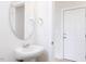 Modern powder room with pedestal sink, oval mirror, and pristine white walls at 147 Little Crk Dr, Lillington, NC 27546