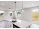 Modern kitchen features white cabinets, stainless steel appliances, a stylish island and pendant lights at 147 Little Crk Dr, Lillington, NC 27546