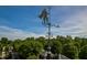 A distinctive trident-bearing weather vane atop the building, set against a backdrop of lush green trees and a clear sky at 1508 W Markham Ave, Durham, NC 27705