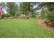 Beautifully landscaped backyard with healthy green lawn, garden beds, and surrounding trees at 1605 Hunting Ridge Rd, Raleigh, NC 27615
