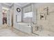 Elegant bathroom featuring a soaking tub, glass-enclosed shower, and access to a spacious walk-in closet at 1605 Hunting Ridge Rd, Raleigh, NC 27615