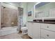 Bathroom with a shower-tub combo, white vanity, and ample counter space at 1605 Hunting Ridge Rd, Raleigh, NC 27615