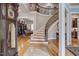 Welcoming foyer featuring a curved staircase, hardwood floors, and classic decor at 1605 Hunting Ridge Rd, Raleigh, NC 27615