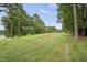 Scenic golf course view with a lush green fairway surrounded by mature trees at 1605 Hunting Ridge Rd, Raleigh, NC 27615
