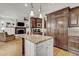 Open concept kitchen with island, stainless appliances and living area with fireplace at 1605 Hunting Ridge Rd, Raleigh, NC 27615