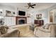 Living room with a stone fireplace, built-in shelving, and hardwood flooring at 1605 Hunting Ridge Rd, Raleigh, NC 27615