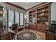 Charming office with a built-in bookshelf, a large window, and hardwood flooring at 1605 Hunting Ridge Rd, Raleigh, NC 27615