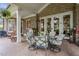 Covered patio with brickwork, elegant chairs surrounding a table, and French doors leading inside at 1605 Hunting Ridge Rd, Raleigh, NC 27615