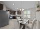 Open-concept dining room with upholstered chairs, chandelier lighting, and stainless steel appliances at 164 Tillburg Ln, Hurdle Mills, NC 27541