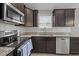 Modern kitchen featuring stainless steel appliances, granite countertops, and dark wood cabinetry at 164 Tillburg Ln, Hurdle Mills, NC 27541