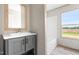 The bathroom features a stylish vanity with sink, a mirror with a wooden frame, and a window at 17 Star Dust Ln, Selma, NC 27576