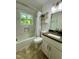 Well-lit bathroom features updated tile, vanity, and shower-tub combination with a window at 1708 Sundial Pl, Raleigh, NC 27610