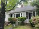 Exterior view of a charming home with grey siding, mature trees and beautiful azalea bushes at 1812 House Ave, Durham, NC 27707