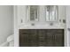 Bathroom features double sinks with dark wood cabinets and a granite countertop, as well as decorative mirrors at 1844 Austin Ridge Pkwy, Wake Forest, NC 27587