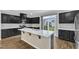 Bright kitchen features black cabinets, hardwood floors, quartz countertops, and stainless steel appliances at 1844 Austin Ridge Pkwy, Wake Forest, NC 27587