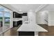 Beautiful kitchen with black cabinets, stainless steel appliances, quartz countertops, and access to the balcony at 1844 Austin Ridge Pkwy, Wake Forest, NC 27587
