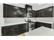 Bright kitchen features black cabinets, quartz countertops, stainless steel appliances, and a gas range at 1844 Austin Ridge Pkwy, Wake Forest, NC 27587