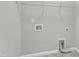 Functional laundry room features tiled flooring, wall-mounted shelving, and all essential hookups for your appliances at 1844 Austin Ridge Pkwy, Wake Forest, NC 27587