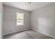 Bright, carpeted bedroom features neutral paint and a large window at 1903 Meadowbrook St, Sanford, NC 27330