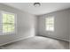 Bright bedroom with neutral paint, carpet, and natural light from the two windows at 1903 Meadowbrook St, Sanford, NC 27330