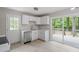 Bright kitchen featuring white cabinets, stainless steel appliances, and sliding glass doors to outdoor deck at 1903 Meadowbrook St, Sanford, NC 27330