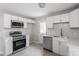 Well-lit kitchen with white cabinetry, stainless steel appliances, and modern finishes at 1903 Meadowbrook St, Sanford, NC 27330