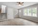 Open living room featuring a ceiling fan, bright windows and stairs to the upper level at 1903 Meadowbrook St, Sanford, NC 27330