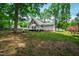 Spacious backyard features mature trees and a home exterior with a deck and stairs at 1915 Redding Ln, Durham, NC 27712