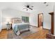 Cozy bedroom with hardwood floors, ceiling fan, and natural light from a window at 1915 Redding Ln, Durham, NC 27712