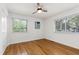 Bedroom with two windows, hardwood floors, ceiling fan, and neutral decor at 1915 Redding Ln, Durham, NC 27712