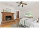 Charming bedroom with a brick fireplace, ceiling fan and hardwood floors at 1915 Redding Ln, Durham, NC 27712