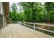Large wooden deck with white railing overlooks a green, landscaped yard with mature trees at 1915 Redding Ln, Durham, NC 27712