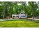 Charming two-story home with lush green yard and mature trees, plus a paved driveway and welcoming front porch at 1915 Redding Ln, Durham, NC 27712