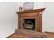 Classic brick fireplace with a wooden mantle and decorative elements at 1915 Redding Ln, Durham, NC 27712