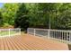 Wooden back deck with white railings overlooks a backyard surrounded by lush trees at 1928 Grace Point Rd, Morrisville, NC 27560